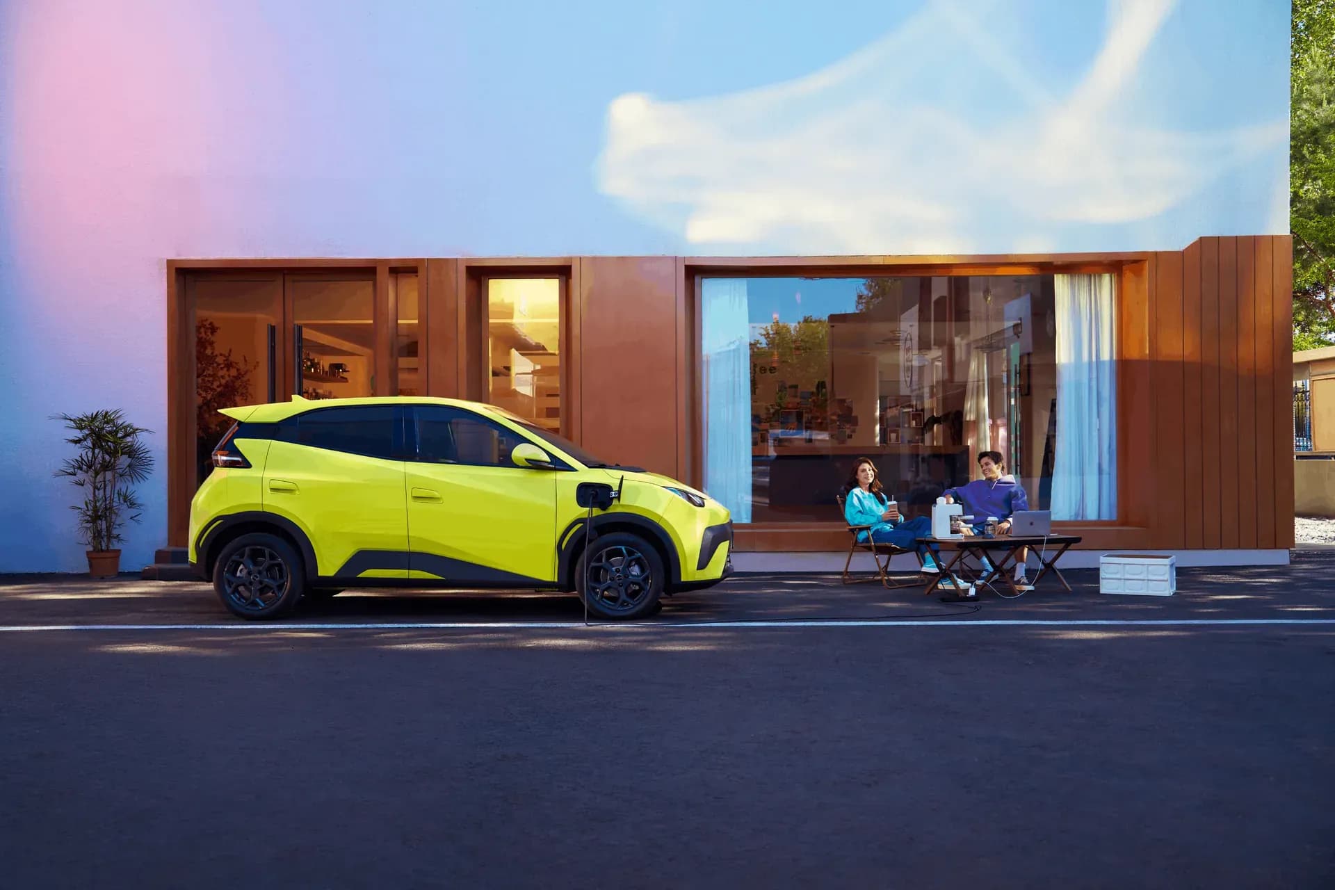 BYD Atto 1 warna Sprout Green sedang diisi daya di depan rumah