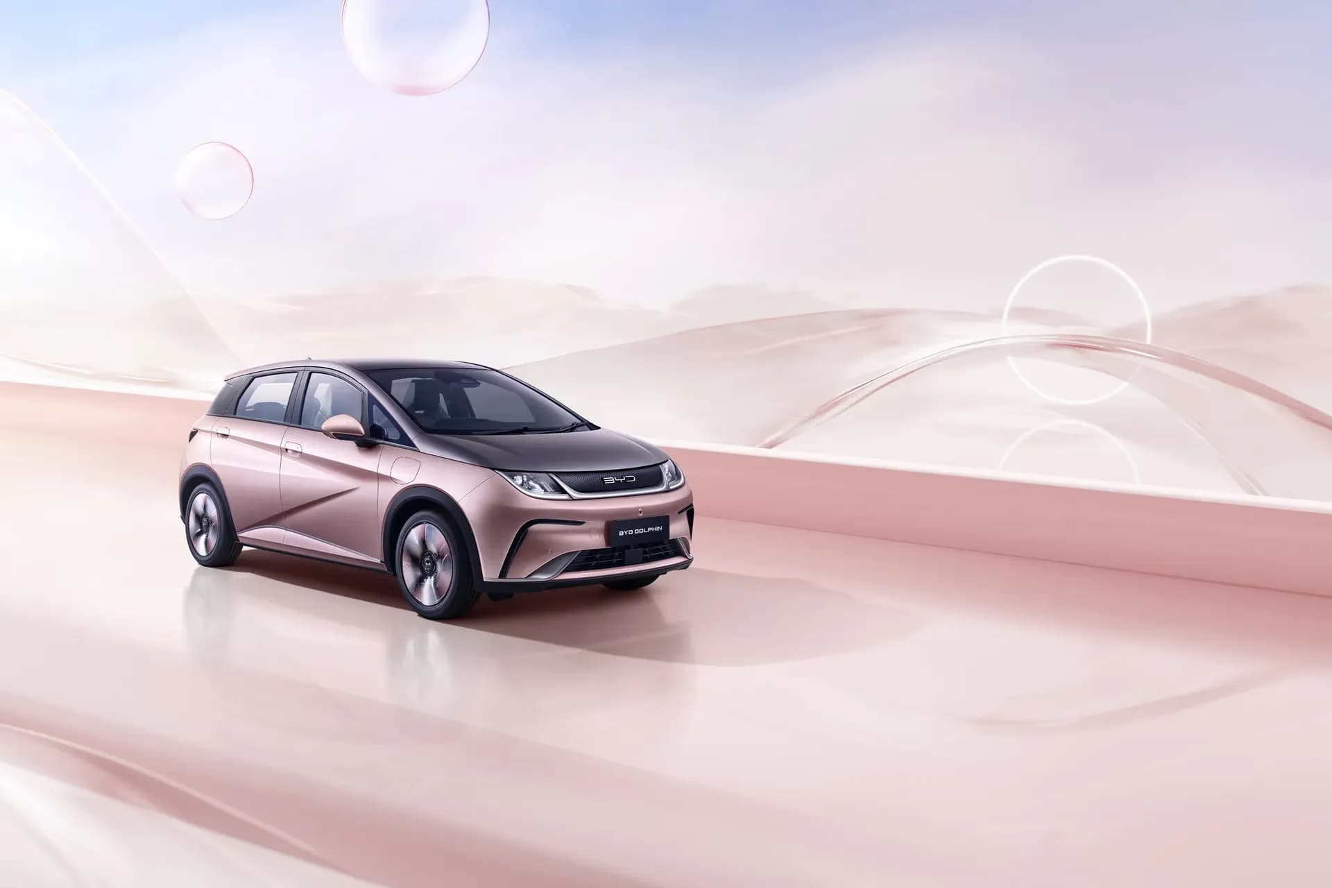 BYD Dolphin warna Coral Pink + Urban Grey di ruang studio bernuansa merah muda