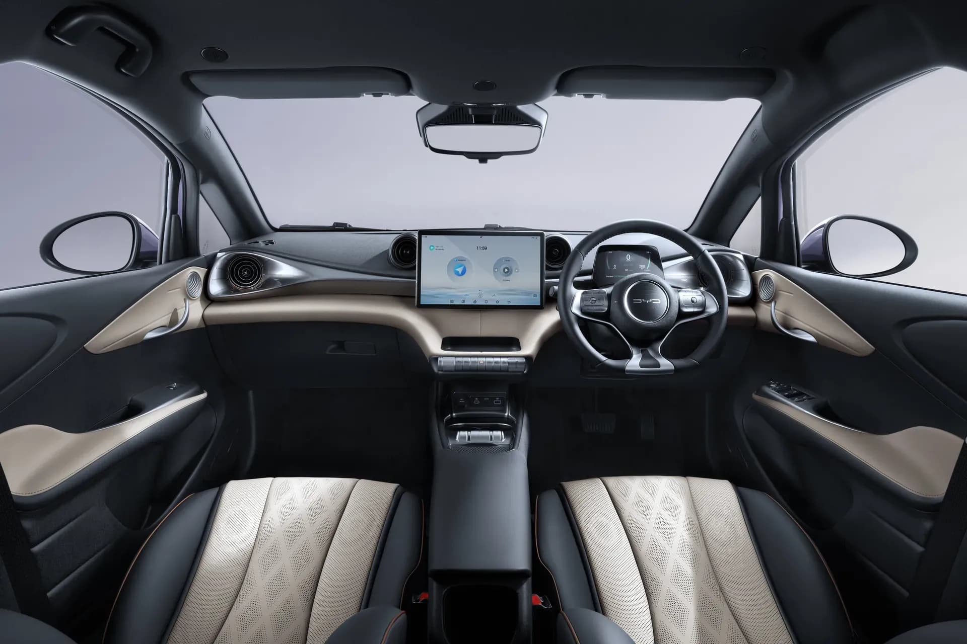Kabin depan BYD Dolphin dengan interior Brown + Black, setir di kanan, dan layar sentuh putar 12,8 inci